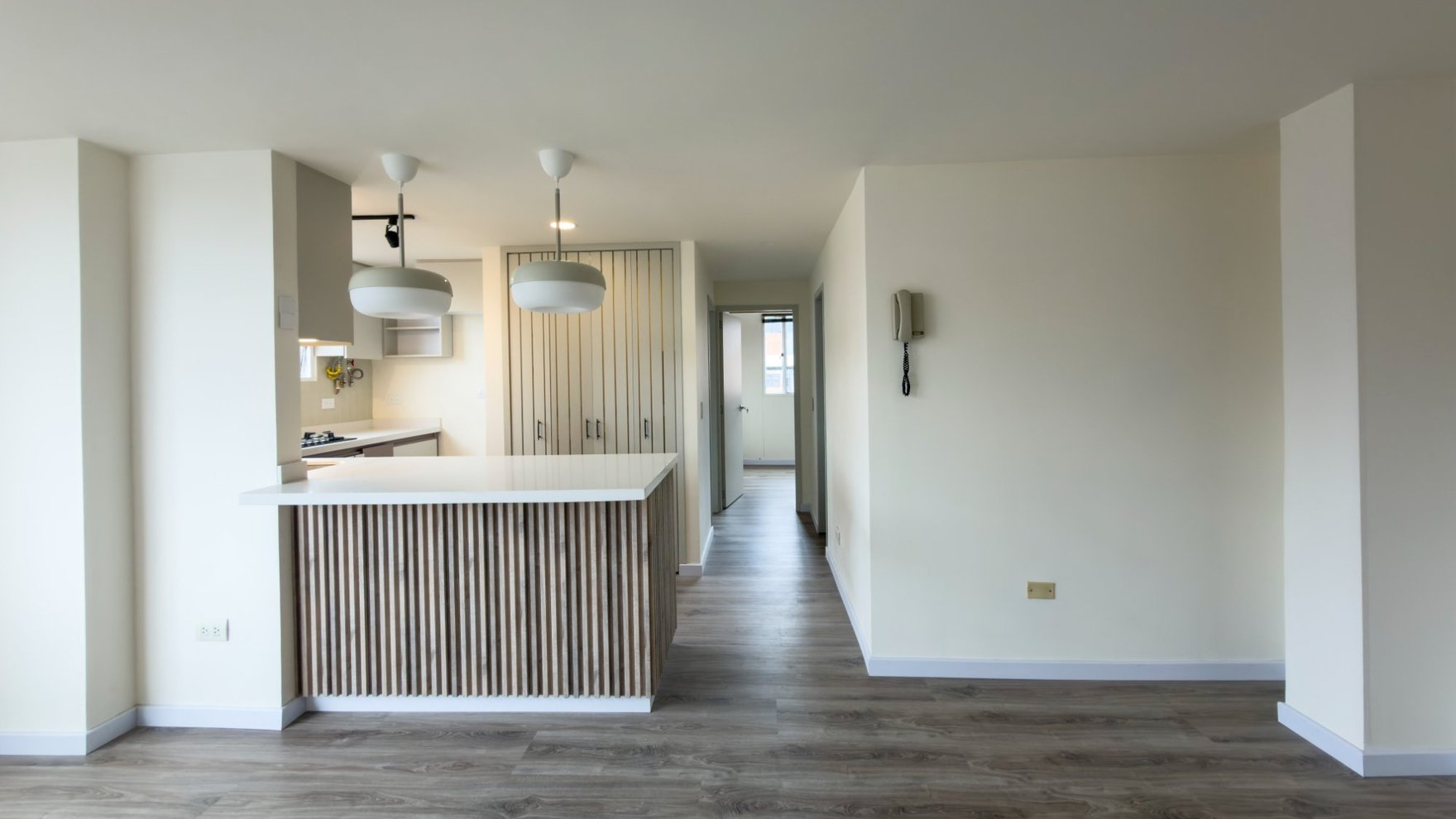 Salón y barra de cocina de un apartamento remodelado en Cedritos, vendido por Morada Espacios.