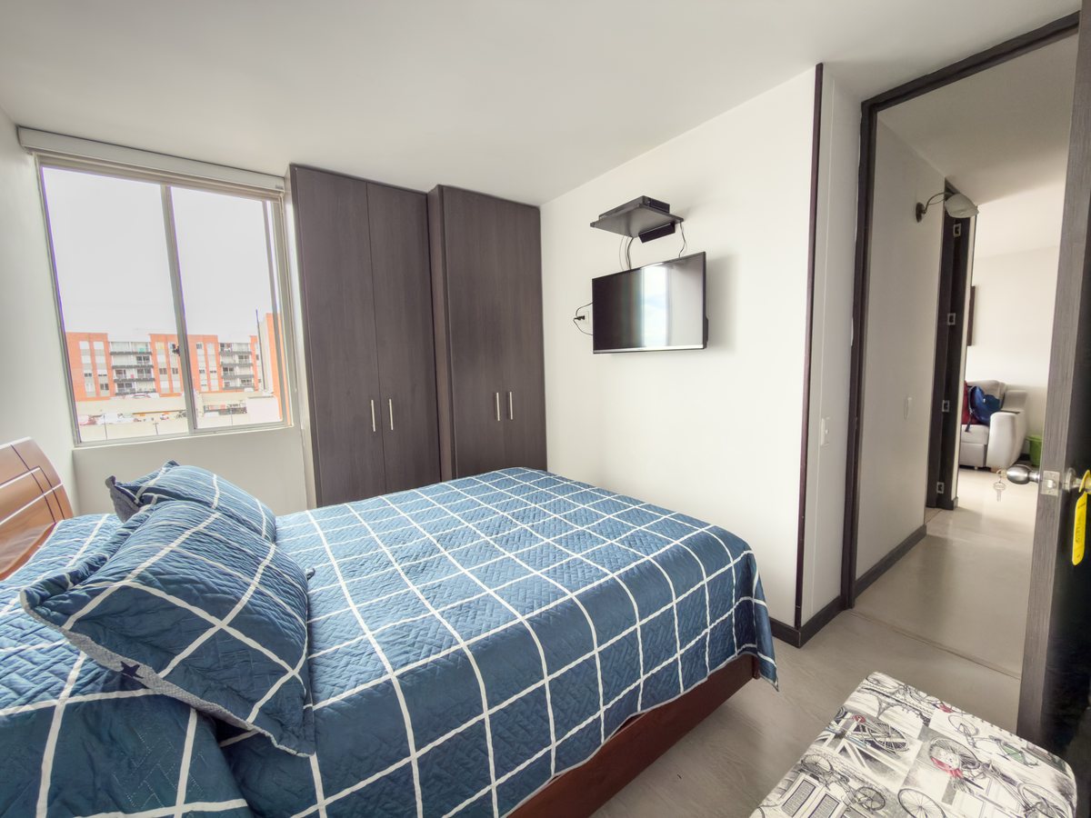 Alcoba principal con clóset de piso a techo y ventana.
